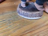 a figurine of a person standing on top of a wooden table
