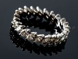 a close up of a silver bracelet on a black surface