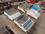 several electronic scales on a table in a warehouse