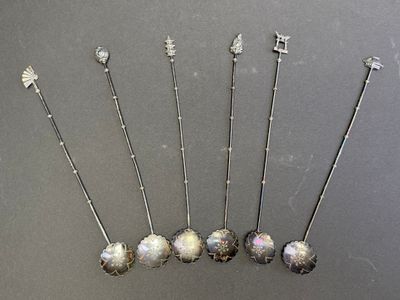 six broches anciennes en argent ornées d'oplites, posées sur une table