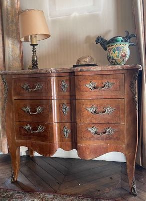 a wooden chest of drawers with a lamp on top of it