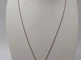 un mannequin blanc portant un collier orné d'un crâne