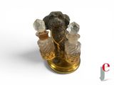 a statue of a dog holding a pair of perfume bottles