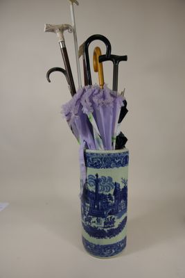 un vase bleu et blanc contenant des parapluies et des manches de parapluie
