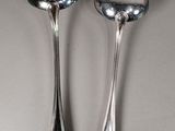 two spoons that are next to each other on a table