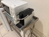 a microwave sitting on top of a table next to a refrigerator