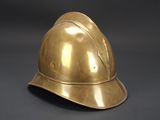a close up of a brass helmet on a black background