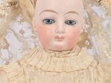 a close up of a doll with blonde hair and blue eyes