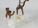 trois figurines représentant des personnes à cheval et un chien