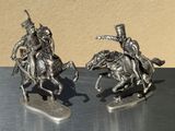 two figurines of men riding horses on a table