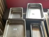 Plusieurs plateaux de nourriture sont posés sur une table dans une cuisine.