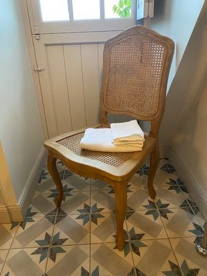 une chaise sur laquelle est posée une serviette, dans un coin de la pièce