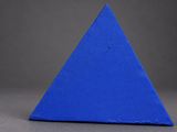 a close up of a blue triangular shaped object on a gray surface
