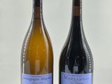 deux bouteilles de vin posées l'une à côté de l'autre sur une surface blanche