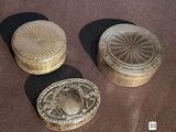 three small metal boxes sitting on top of a table next to each other