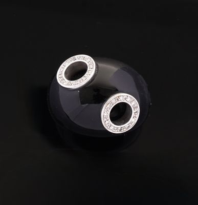 pair of black and white earrings with diamonds on a black surface