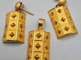 a pair of gold earrings with pyramids on them