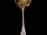 a silver spoon with a gold handle on a black background
