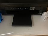 une imprimante posée sur un bureau, avec une souris dessus