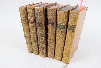 plusieurs vieux livres sont empilés sur une surface blanche