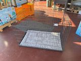 a cage with a dog inside of it on the floor