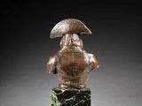 a bronze busturine of a man with an umbrella on a marble base