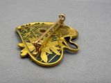 a gold pin with a butterfly on it on a table