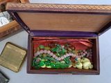 a wooden box filled with glass beads and other items