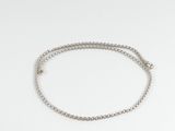 un gros plan d'un bracelet en argent muni d'une chaîne, sur fond blanc