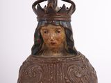 une vieille statue représentant une femme coiffée d'une couronne