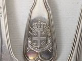 three spoons and a spoon with a coat of arms on them