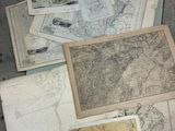 de nombreuses cartes anciennes jonchent le sol de cette pièce