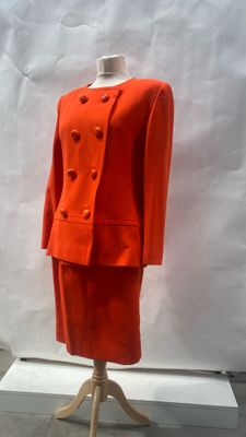 an orange suit on a mannequin stand in front of a white backdrop