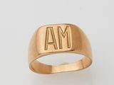 a close up of a gold ring with the letter m on it