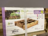 une caisse de matériel de jardinage posée sur un banc en bois