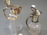 a silver and glass pitcher and a silver spoon on a table