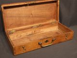 a small wooden suitcase with a handle on a black background