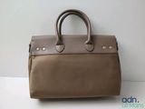 a brown handbag sitting on top of a white table