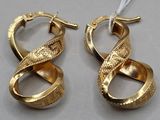 two pairs of gold earrings with a twisted design on them