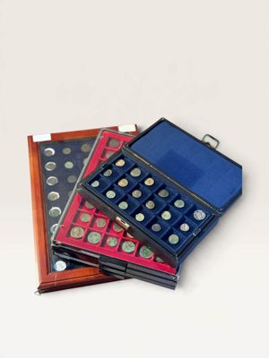 several different types of coins are in a case on a white surface