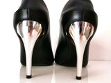 a pair of black high heeled shoes on a white surface