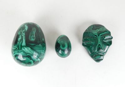 three pieces of green marble on a white surface