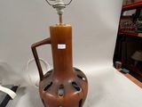 a brown vase that has a light on top of it
