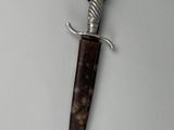 a close up of a knife with a wooden handle on a white surface