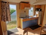 une cuisine équipée d'une cuisinière avec four et d'un réfrigérateur
