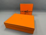 une boîte orange ornée d'un nœud et contenant une paire de lunettes