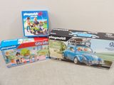trois boîtes de Playmobil posées sur une table
