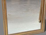 a mirror that has a gold frame on it