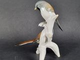 a figurine of a bird sitting on a branch