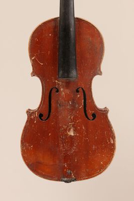 an old violin sitting on top of a white surface